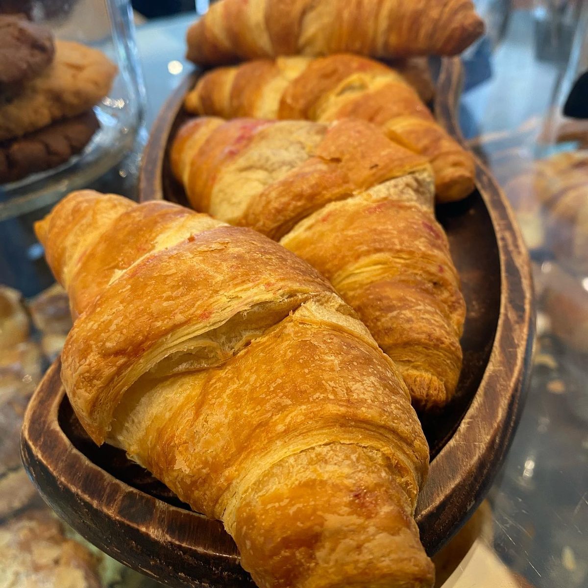 Butter croissants in a wooden bowl on the counter